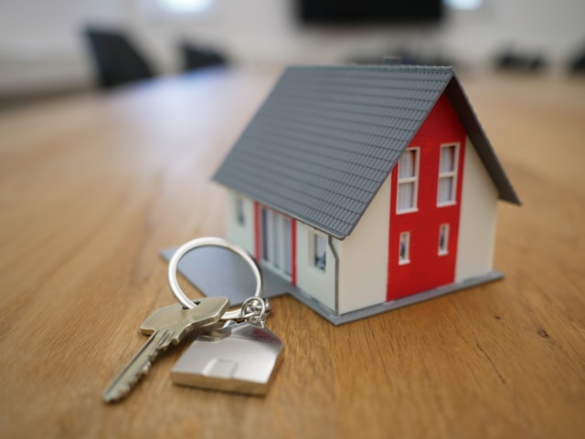 a house figurine with keys next to it