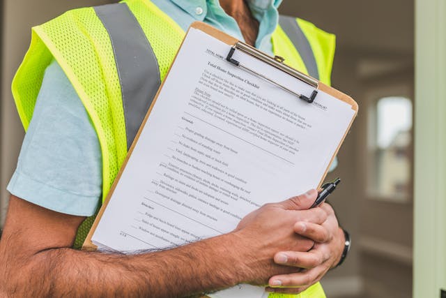 Person holding a home inspection checklist on a clipboard