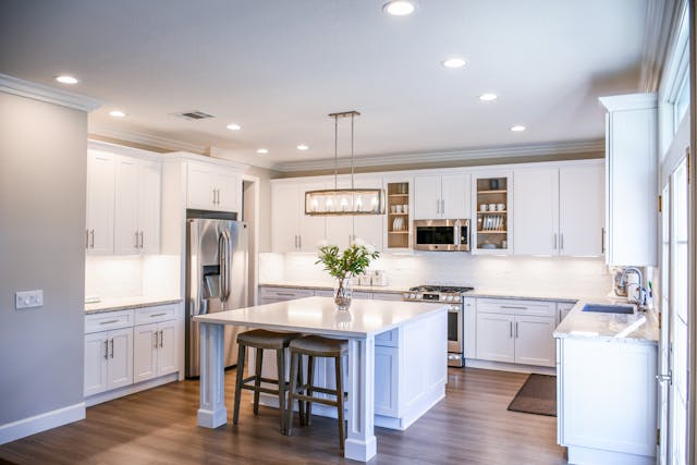 a kitchen with white granite counters and stainless steel appliances