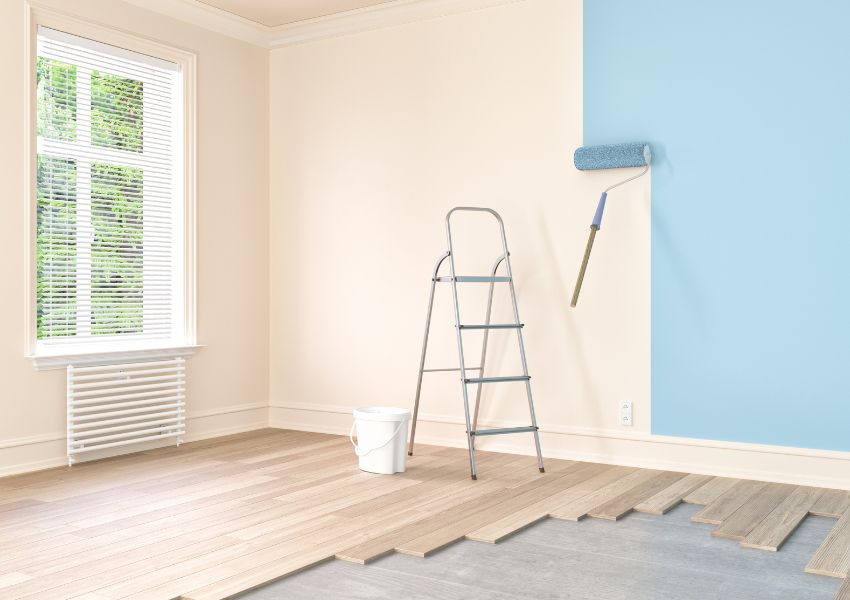 a lander and paint roller in a white room, with the roller painting the walls blue