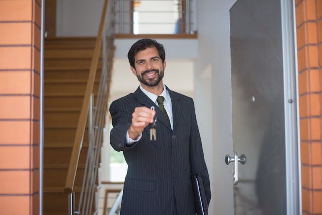 property manager holding up house keys in a doorway