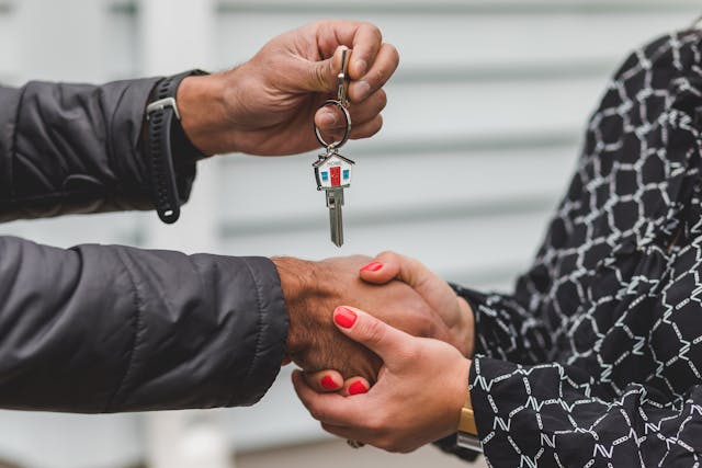 two people shaking hands and exchanging house keys