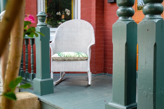 a white rocking chair on a front porch