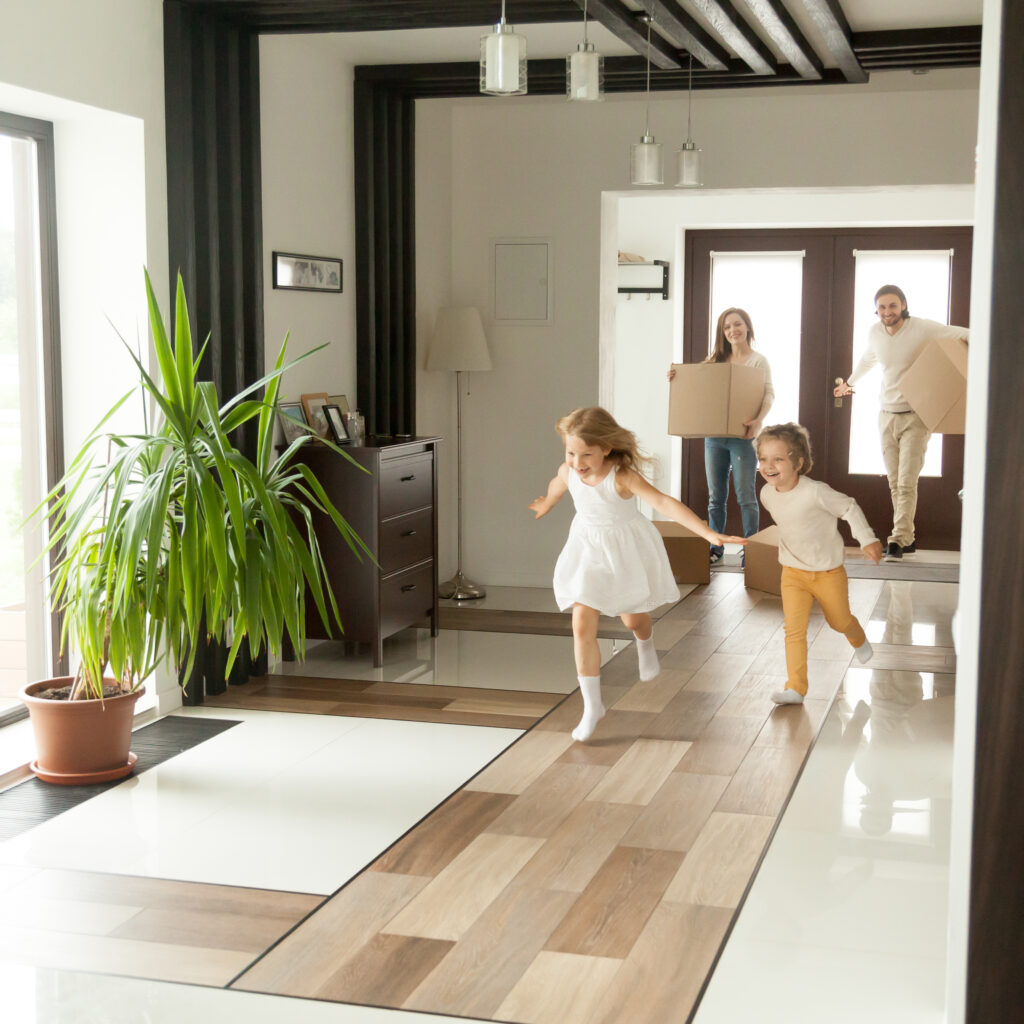 Happy rental tenants moving in with kids playing