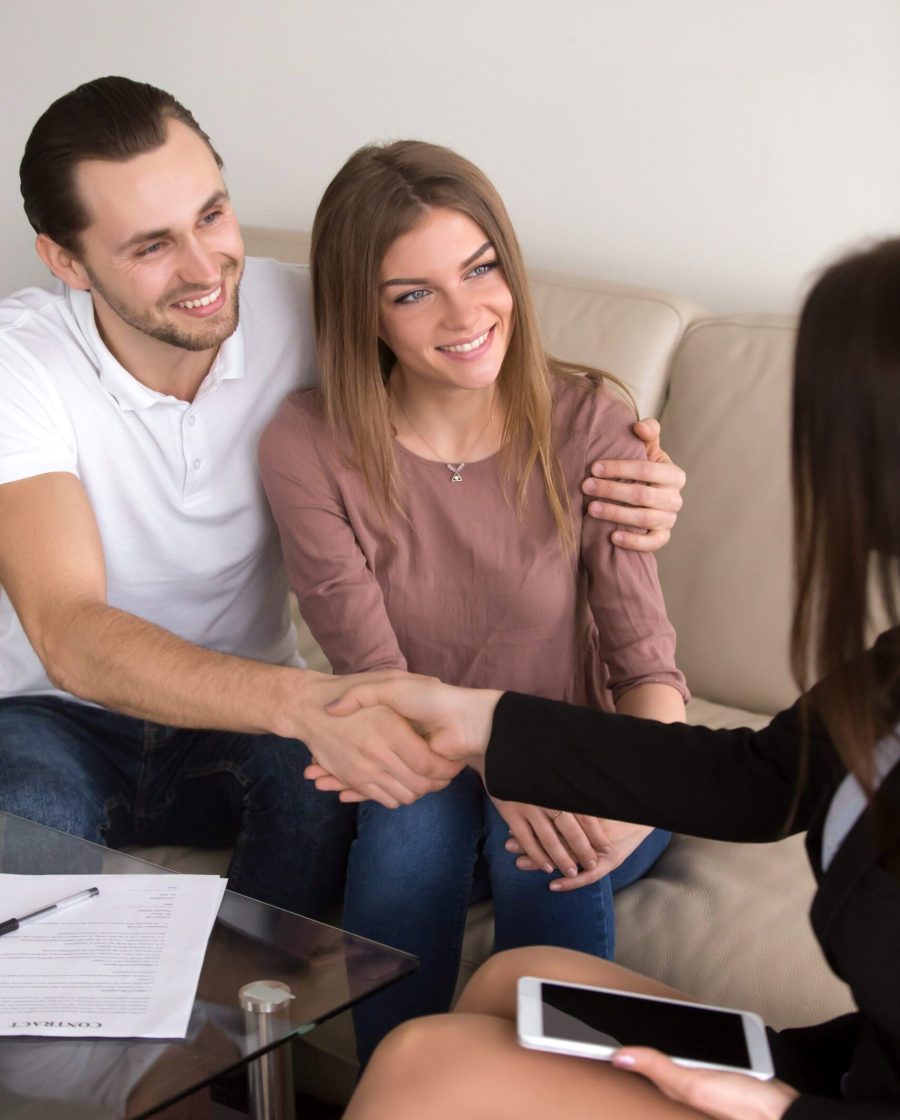 Happy,Cheerful,Couple,Shaking,Hands,With,Female,Travel,Manager,Or Young married couple talking with a real-estate agent visiting apartment for sale or for rent.